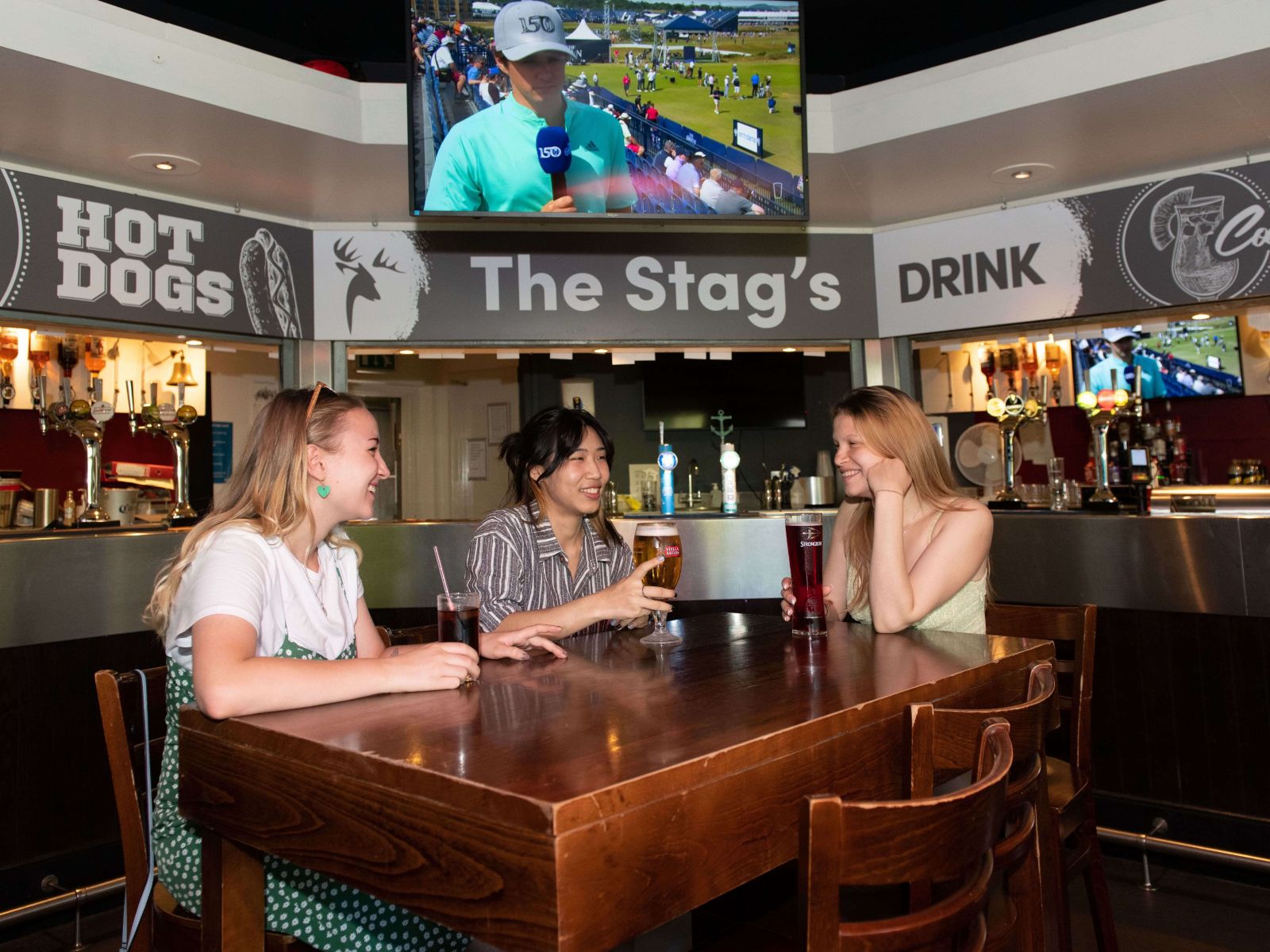 Three students sit at a table in The Stag's