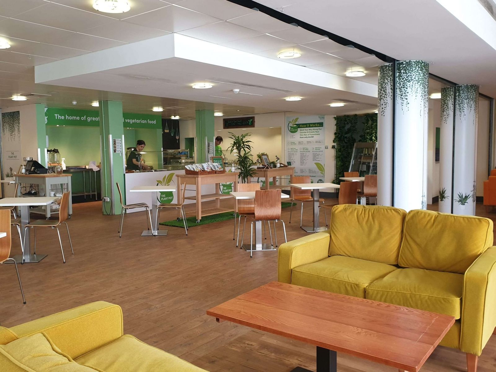 The Plant Pot counter, green sofas and seating in the cafe area