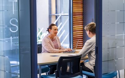 Personal Academic Tutor sitting at a desk with a laptop talking with a student